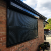 A Black Domestic Security Shutter In A Residential Garden