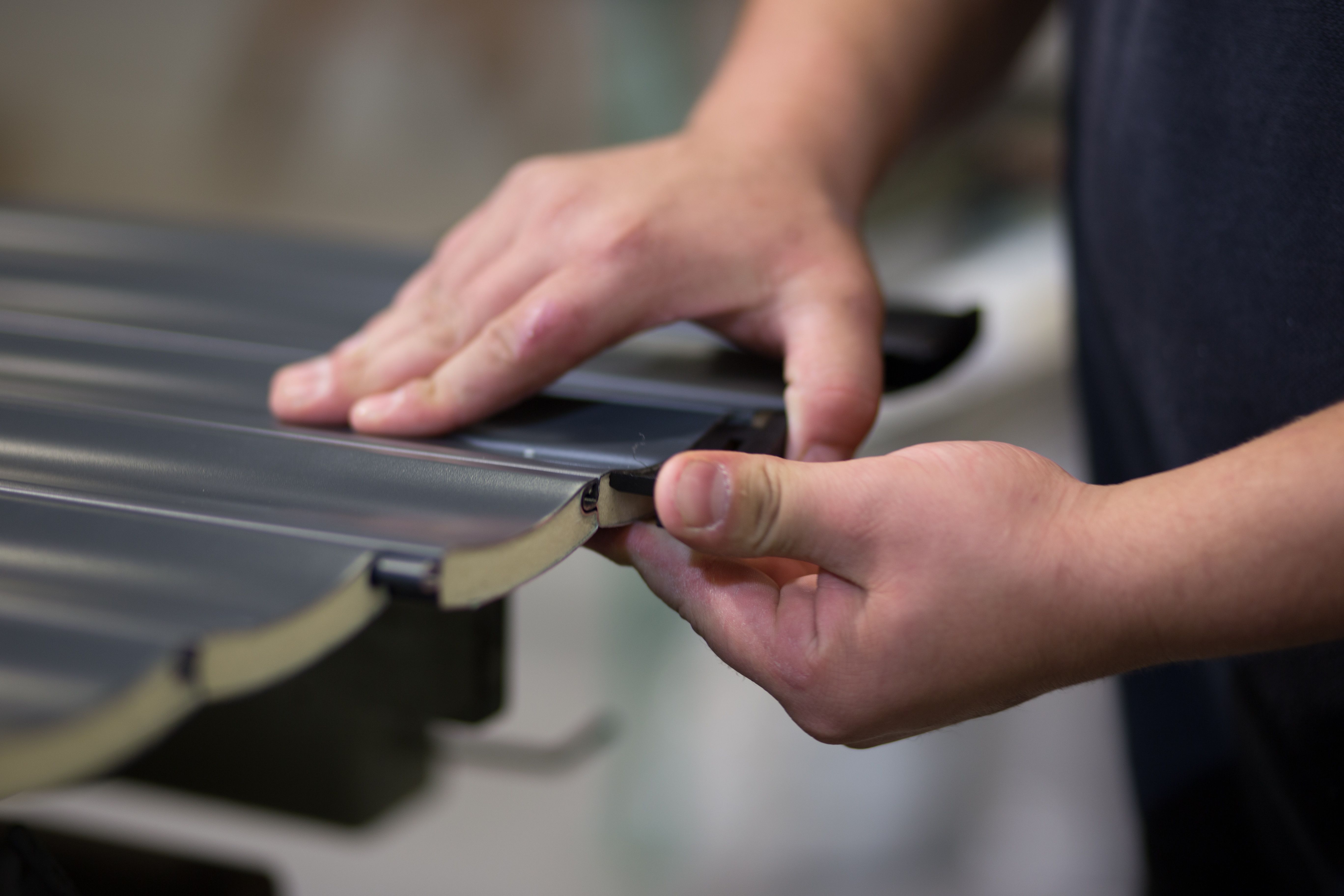 Factory Worker Assembling Roller Garage Door Parts